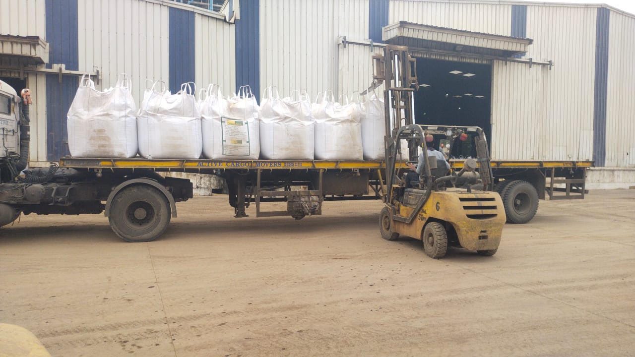 Forklift loading fly ash jumbo bags onto truck